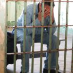 An inmate cries behind bars