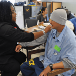 USFNS nurse Norlissa Cooper taking the blood pressure of Sonny Nguyen