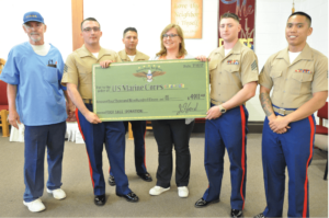 The United States Marines accepting the check from Madeline Tenney