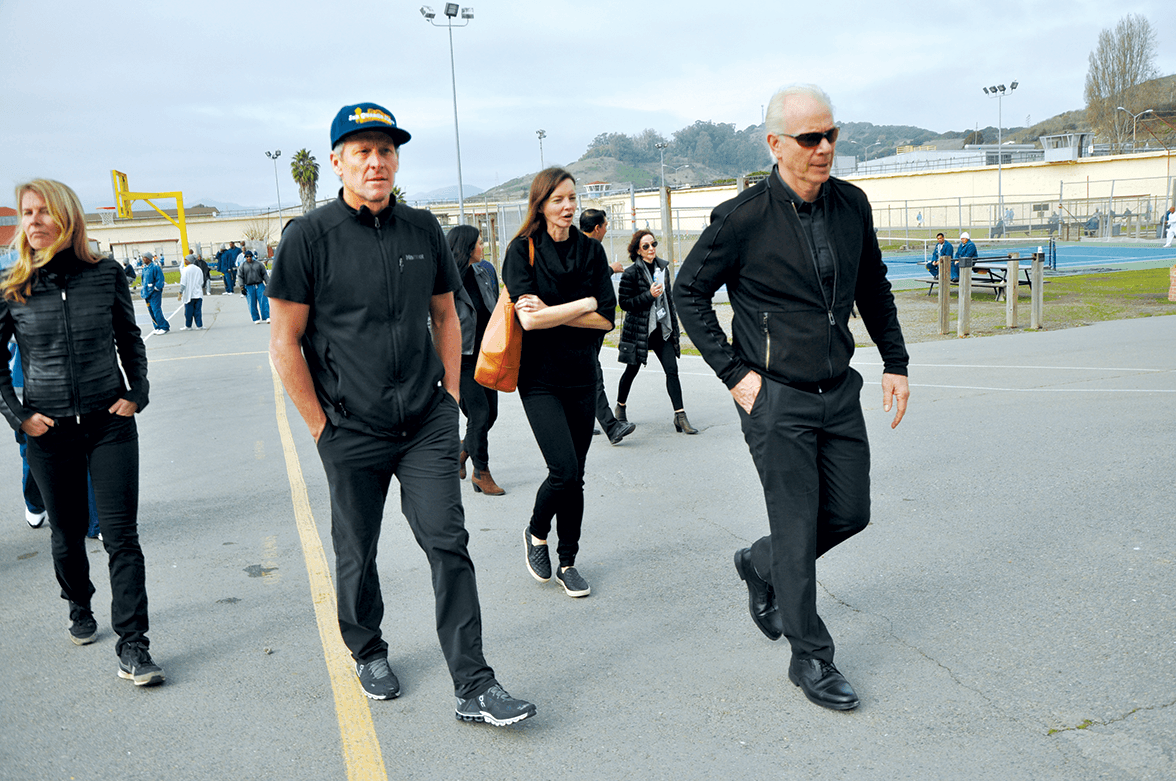 Lance Armstrong and Chris Redlitz walking across San Quentin’s Lower Yard