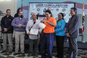 N.A. Chaderjian youth graduate Luis Alvardo receiving his certificate