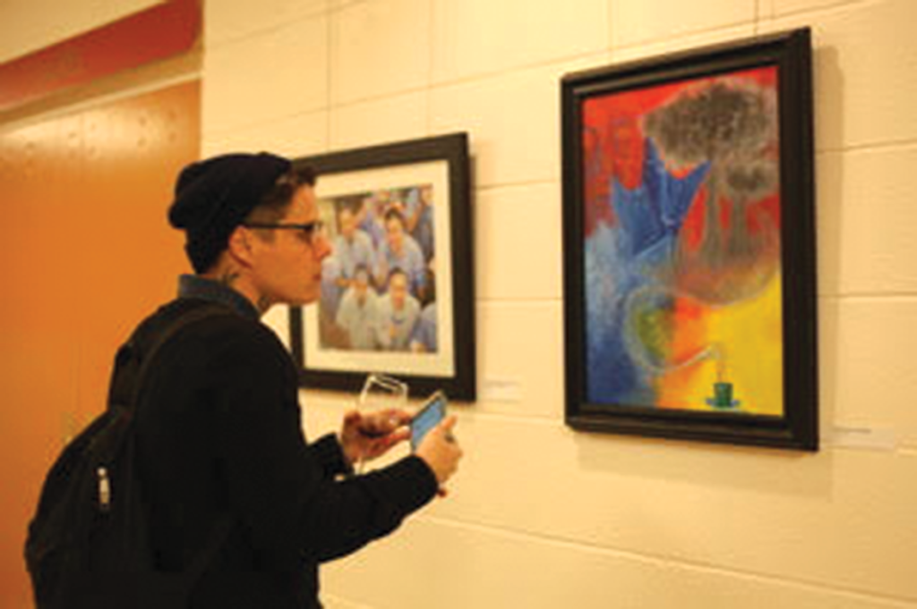 Patron admiring Patrick Maloney’s work (right)