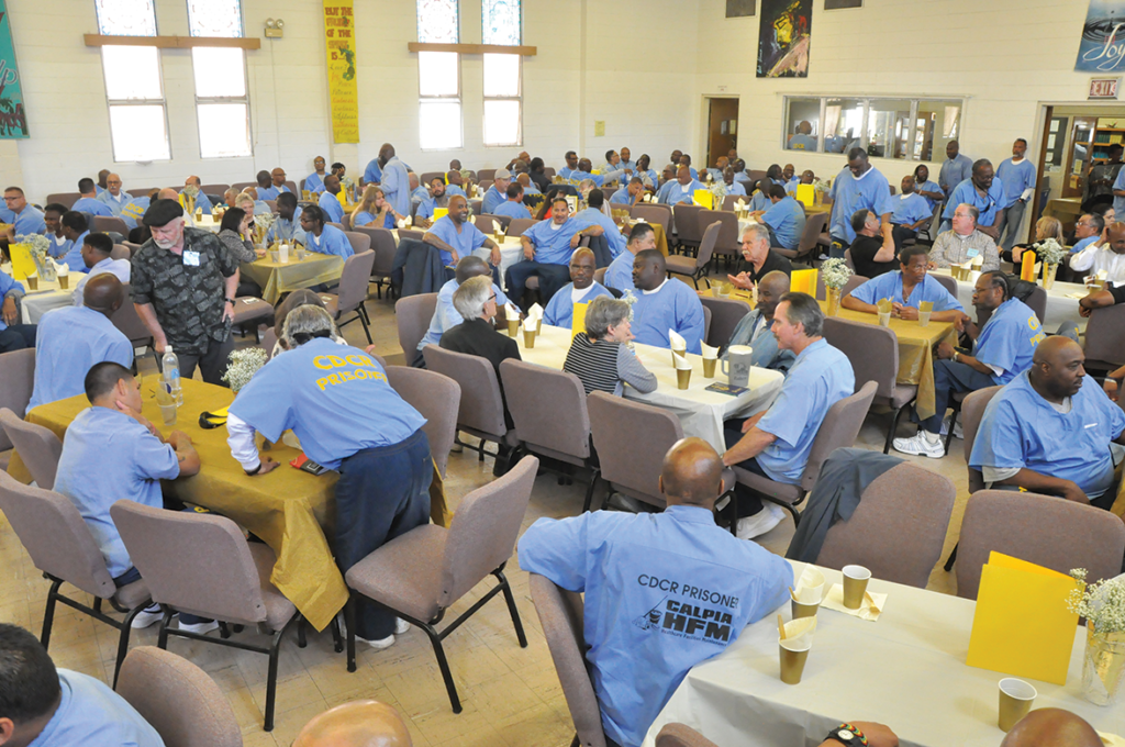 Volunteers & Inmate guest chatting in pre-banquet fellowship as music plays