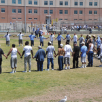 Visitors and inmates making the circle of peace at the Lower Yard