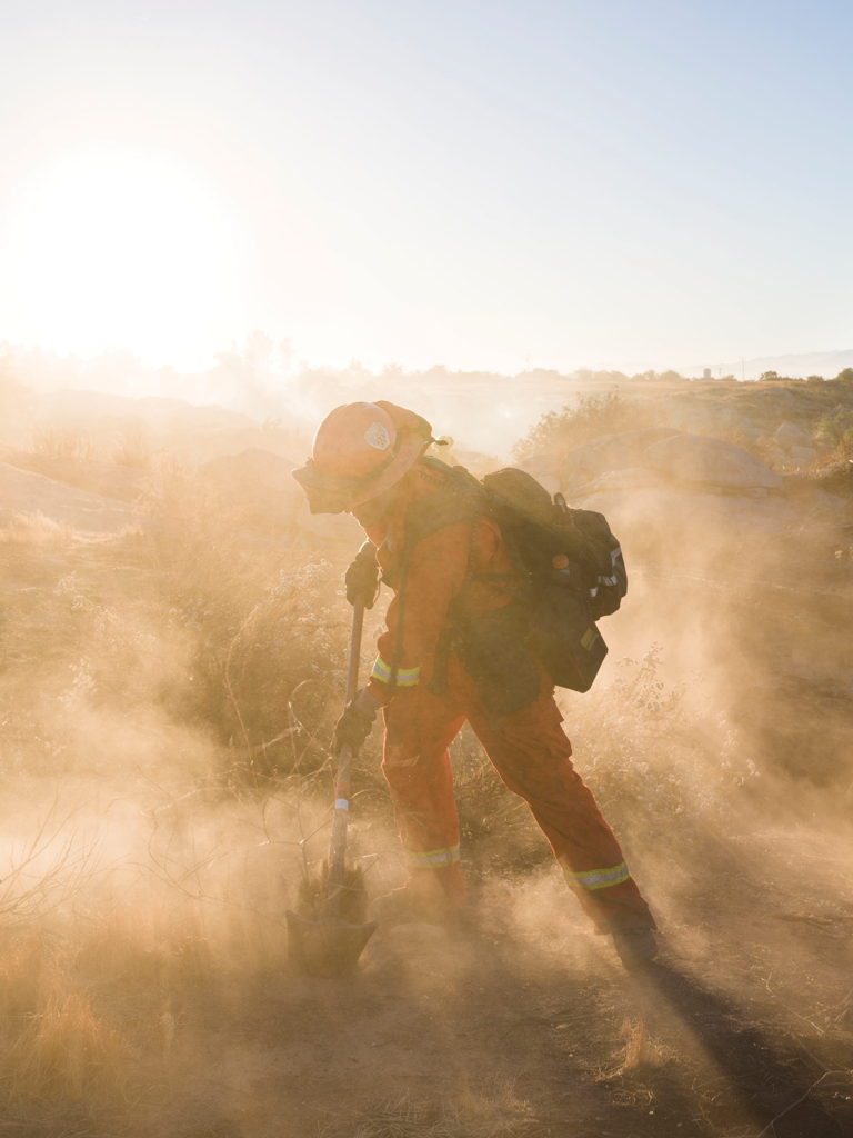 Rainbow Crew firefighter cutting a fire line to stop a small fire near Hemet. Photo by Peter Bohler/Redux.